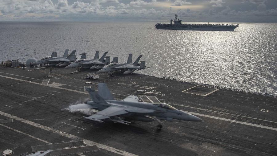 In this photo provided by U.S. Navy,  an F/A-18E Super Hornet lands on the flight deck of the USS Ronald Reagan (CVN 76), as USS Nimitz (CVN 68) steams alongside in the South China Sea, Monday, July 6, 2020. China on Monday, July 6, accused the U.S. of flexing its military muscles in the South China Sea by conducting joint exercises with two U.S. aircraft carrier groups in the strategic waterway.(Mass Communication Specialist 2nd Class Samantha Jetzer/U.S. Navy via AP)