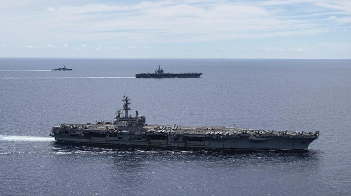 In this photo provided by U.S. Navy, the USS Ronald Reagan (CVN 76, front) and USS Nimitz (CVN 68, rear) Carrier Strike Groups sail together in formation, in the South China Sea, Monday, July 6, 2020. China on Monday, July 6, accused the U.S. of flexing its military muscles in the South China Sea by conducting joint exercises with two U.S. aircraft carrier groups in the strategic waterway.(Mass Communication Specialist 3rd Class Jason Tarleton/U.S. Navy via AP)