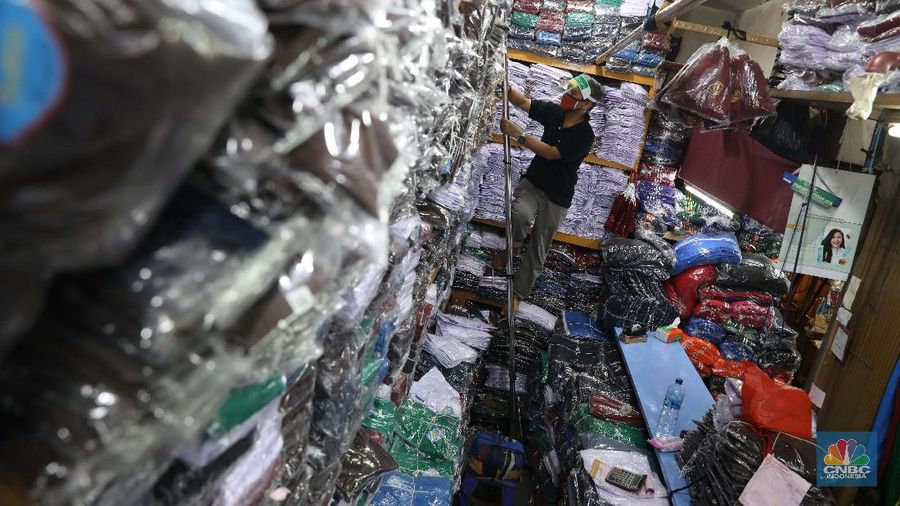 Burhan Menjaga toko di pasar Jatinegara Jakarta Timur, Rabu 8/7. Sejumlah toko di Pasar Jatinegara, Jakarta Timur,  mengaku kehilangan banyak pembeli karena tidak ada kepastian kapan sekolah kembali dibuka setelah Pembatasan Sosial Berskala Besar (PSBB) akibat pandemi virus corona. Burhan 48 tahun seorang pemilik toko baju seragam sekolah mengeluhkan turunnya hasil dagang. 