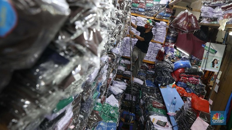 Burhan Menjaga toko di pasar Jatinegara Jakarta Timur, Rabu 8/7. Sejumlah toko di Pasar Jatinegara, Jakarta Timur,  mengaku kehilangan banyak pembeli karena tidak ada kepastian kapan sekolah kembali dibuka setelah Pembatasan Sosial Berskala Besar (PSBB) akibat pandemi virus corona. Burhan 48 tahun seorang pemilik toko baju seragam sekolah mengeluhkan turunnya hasil dagang. 