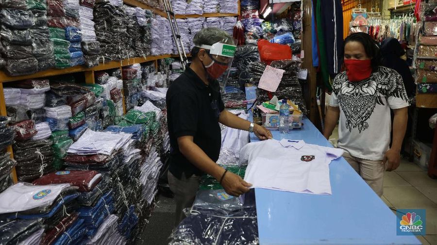 Burhan Menjaga toko di pasar Jatinegara Jakarta Timur, Rabu 8/7. Sejumlah toko di Pasar Jatinegara, Jakarta Timur, mengaku kehilangan banyak pembeli karena tidak ada kepastian kapan sekolah kembali dibuka setelah Pembatasan Sosial Berskala Besar (PSBB) akibat pandemi virus corona. Burhan 48 tahun seorang pemilik toko baju seragam sekolah mengeluhkan turunnya hasil dagang.