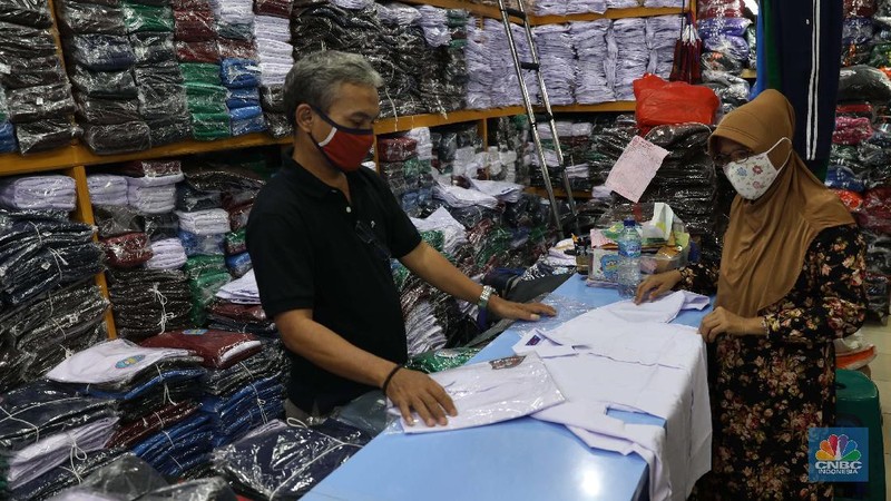 Burhan Menjaga toko di pasar Jatinegara Jakarta Timur, Rabu 8/7. Sejumlah toko di Pasar Jatinegara, Jakarta Timur,  mengaku kehilangan banyak pembeli karena tidak ada kepastian kapan sekolah kembali dibuka setelah Pembatasan Sosial Berskala Besar (PSBB) akibat pandemi virus corona. Burhan 48 tahun seorang pemilik toko baju seragam sekolah mengeluhkan turunnya hasil dagang. 