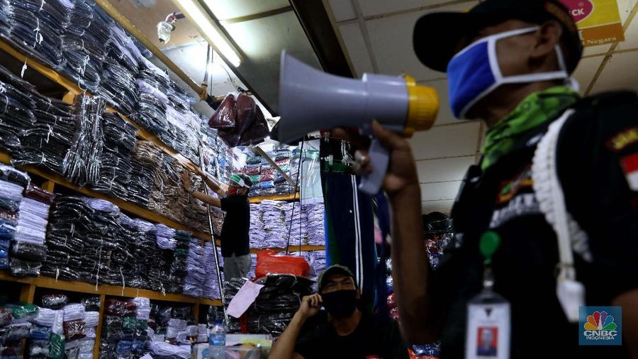 Burhan Menjaga toko di pasar Jatinegara Jakarta Timur, Rabu 8/7. Sejumlah toko di Pasar Jatinegara, Jakarta Timur,  mengaku kehilangan banyak pembeli karena tidak ada kepastian kapan sekolah kembali dibuka setelah Pembatasan Sosial Berskala Besar (PSBB) akibat pandemi virus corona. Burhan 48 tahun seorang pemilik toko baju seragam sekolah mengeluhkan turunnya hasil dagang. 