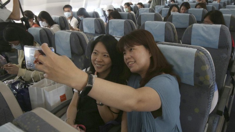 An epidemic prevention staff member shows disinfection measures to participants during a mock trip abroad at Taipei Songshan Airport in Taipei, Taiwan, Tuesday, July 7, 2020. Dozens of would-be travelers acted as passengers in an activity organized by Taiwan’s Civil Aviation Administration to raise awareness of procedures to follow when passing through customs and boarding their plane at Taipei International Airport. (AP Photo/Chiang Ying-ying)