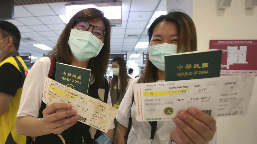 An epidemic prevention staff member shows disinfection measures to participants during a mock trip abroad at Taipei Songshan Airport in Taipei, Taiwan, Tuesday, July 7, 2020. Dozens of would-be travelers acted as passengers in an activity organized by Taiwan’s Civil Aviation Administration to raise awareness of procedures to follow when passing through customs and boarding their plane at Taipei International Airport. (AP Photo/Chiang Ying-ying)
