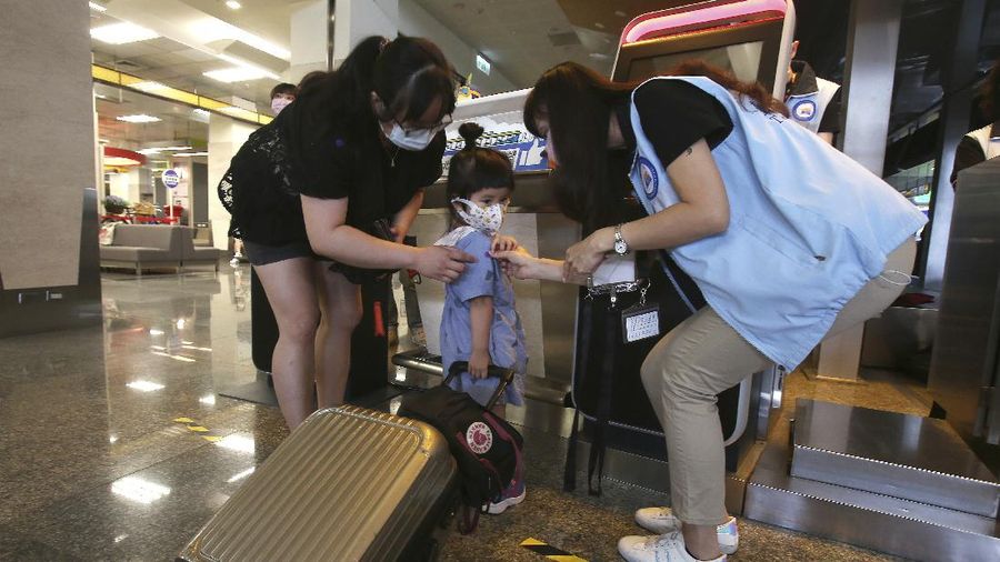 An epidemic prevention staff member shows disinfection measures to participants during a mock trip abroad at Taipei Songshan Airport in Taipei, Taiwan, Tuesday, July 7, 2020. Dozens of would-be travelers acted as passengers in an activity organized by Taiwan’s Civil Aviation Administration to raise awareness of procedures to follow when passing through customs and boarding their plane at Taipei International Airport. (AP Photo/Chiang Ying-ying)