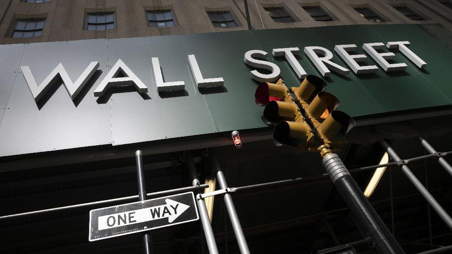 FILE -In this June 16, 2020 file photo, a sign for a Wall Street building is shown in New York. Earnings reporting season is about to get underway for big companies, and the forecasts are grim. Wall Street expects S&P 500 companies to report profits plunged by the most since the depths of the Great Recession during the second quarter. Earnings reports tend to matter deeply to investors because stock prices track the path of earnings over the long term.   (AP Photo/Mark Lennihan, File)