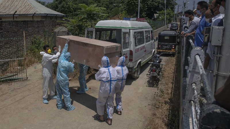 A snack vendor walks in a lane as health workers arrive to screen people for COVID-19 symptoms at a slum in Mumbai, India, Friday, July 10, 2020. India has overtaken Russia to become the third worst-affected nation by the coronavirus pandemic. (AP Photo/Rafiq Maqbool)