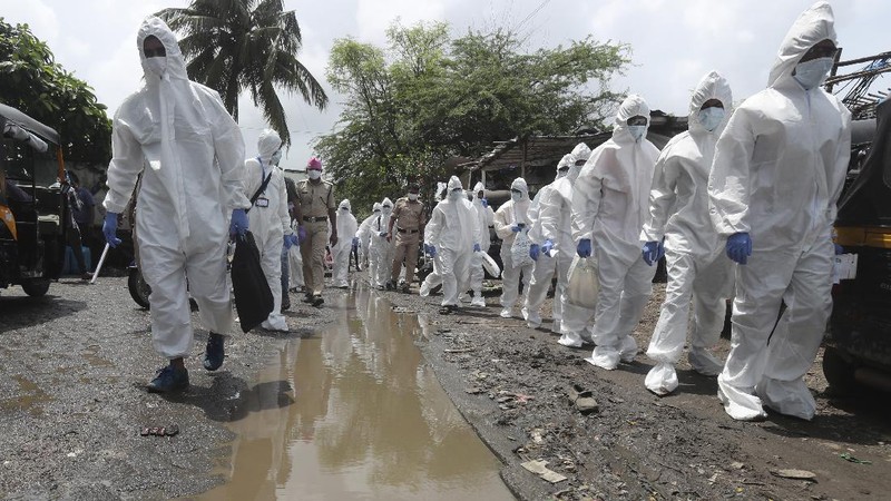 A snack vendor walks in a lane as health workers arrive to screen people for COVID-19 symptoms at a slum in Mumbai, India, Friday, July 10, 2020. India has overtaken Russia to become the third worst-affected nation by the coronavirus pandemic. (AP Photo/Rafiq Maqbool)
