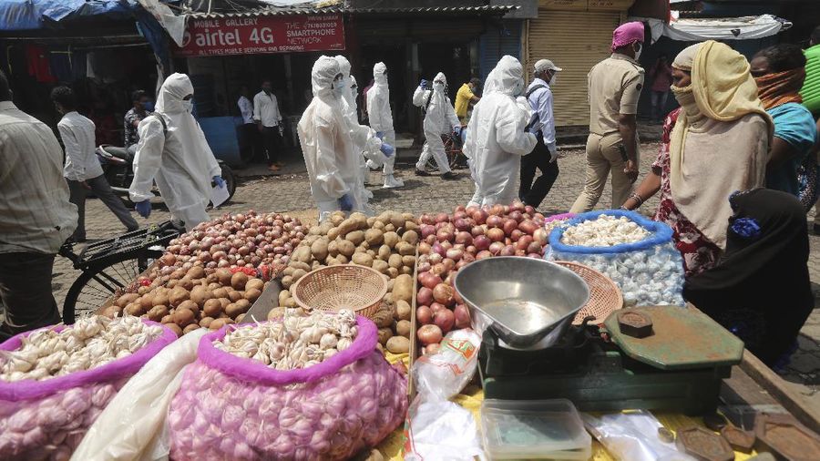 A snack vendor walks in a lane as health workers arrive to screen people for COVID-19 symptoms at a slum in Mumbai, India, Friday, July 10, 2020. India has overtaken Russia to become the third worst-affected nation by the coronavirus pandemic. (AP Photo/Rafiq Maqbool)