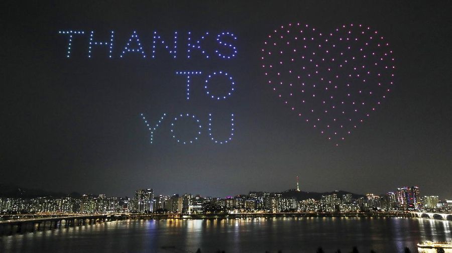 In this on Saturday, July 4, 2020, photo, some 400 drones fly over the Han River showing messages of appreciation for medical workers during the coronavirus pandemic in Seoul, South Korea.The letters read 