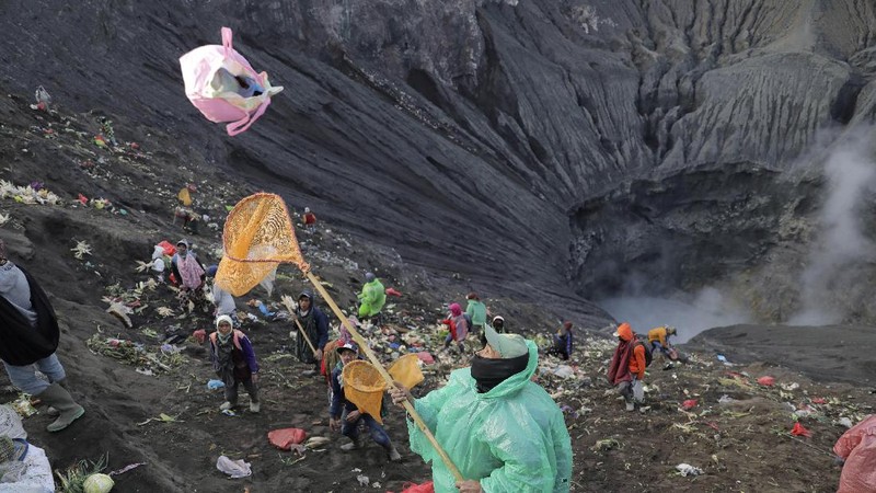 People wearing face masks as a precaution against the new coronavirus walk on a street in Jakarta, Indonesia, Tuesday, July 7, 2020. (AP Photo/Achmad Ibrahim)