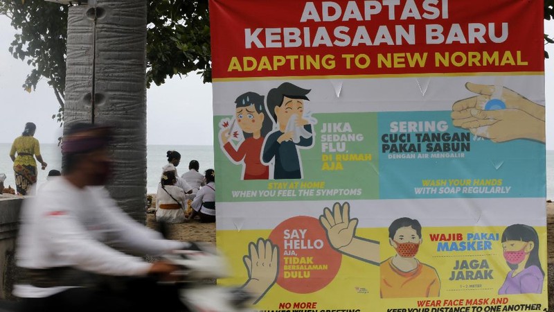 People wearing face masks as a precaution against the new coronavirus walk on a street in Jakarta, Indonesia, Tuesday, July 7, 2020. (AP Photo/Achmad Ibrahim)