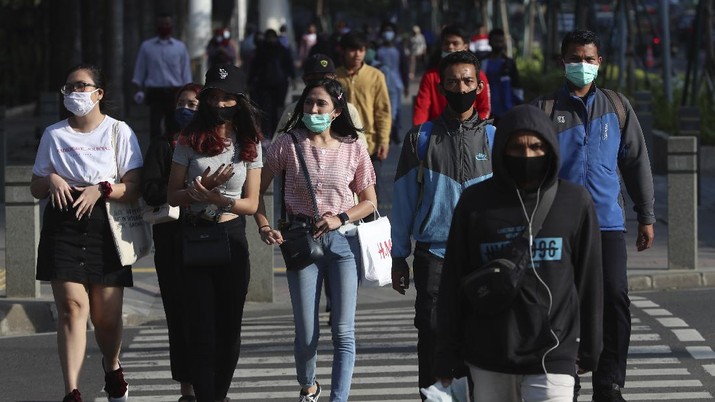 Virus Outbreak Indonesia People wearing face masks as a precaution against the new coronavirus walk on a street in Jakarta, Indonesia, Tuesday, July 7, 2020. (AP Photo/Achmad Ibrahim)