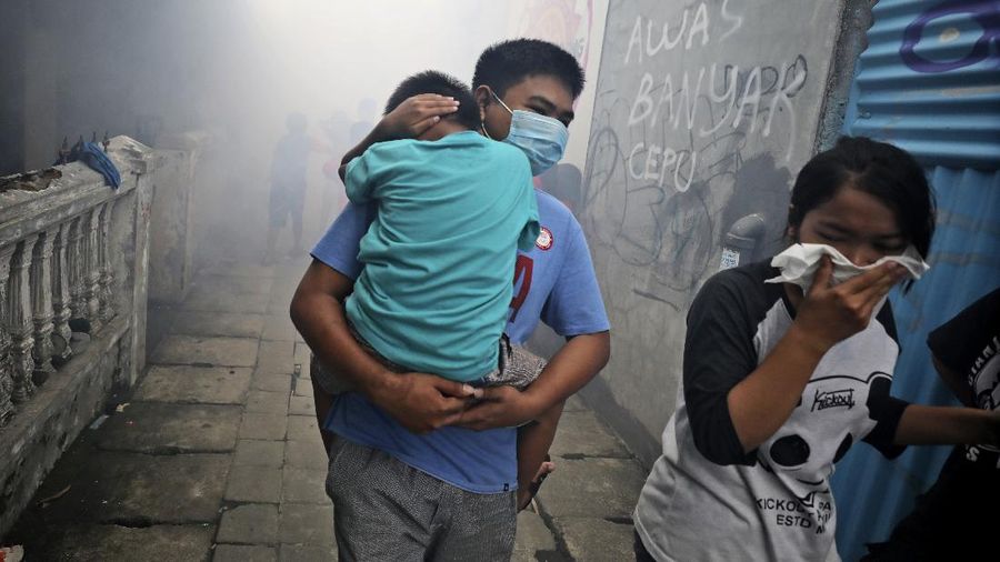 A worker fumigates a slum to prevent an outbreak of dengue fever in Jakarta, Indonesia, Wednesday, April 22, 2020. While 2019 was the worst year on record for global dengue cases, experts fear an even bigger surge is possible because their efforts to combat it were hampered by restrictions imposed in the coronavirus pandemic. (AP Photo/Dita Alangkara)
