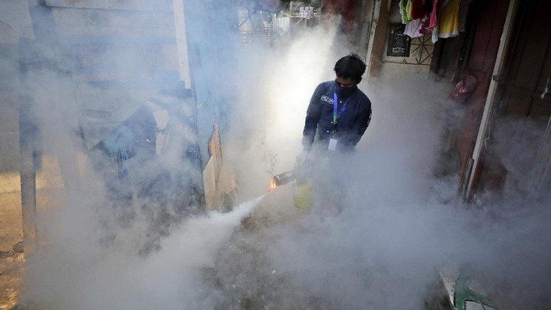 A worker fumigates a slum to prevent an outbreak of dengue fever in Jakarta, Indonesia, Wednesday, April 22, 2020. While 2019 was the worst year on record for global dengue cases, experts fear an even bigger surge is possible because their efforts to combat it were hampered by restrictions imposed in the coronavirus pandemic. (AP Photo/Dita Alangkara)