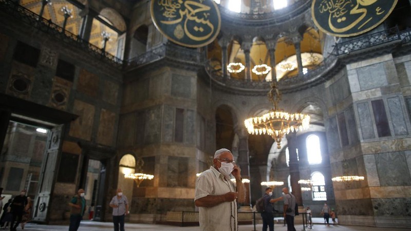 People use their mobile to take a selfie picture outside the now closed Byzantine-era Hagia Sophia, one of Istanbul's main tourist attractions in the historic Sultanahmet district of Istanbul, Saturday, July 11, 2020. Turkey's President Recep Tayyip Erdogan formally reconverted Hagia Sophia into a mosque and declared it open for Muslim worship, hours after a high court annulled a 1934 decision that had made the religious landmark a museum.The decision sparked deep dismay among Orthodox Christians. Originally a cathedral, Hagia Sophia was turned into a mosque after Istanbul's conquest by the Ottoman Empire but had been a museum for the last 86 years, drawing millions of tourists annually. (AP Photo/Emrah Gurel)