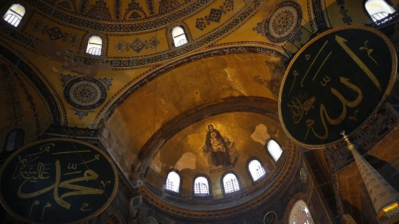 People use their mobile to take a selfie picture outside the now closed Byzantine-era Hagia Sophia, one of Istanbul's main tourist attractions in the historic Sultanahmet district of Istanbul, Saturday, July 11, 2020. Turkey's President Recep Tayyip Erdogan formally reconverted Hagia Sophia into a mosque and declared it open for Muslim worship, hours after a high court annulled a 1934 decision that had made the religious landmark a museum.The decision sparked deep dismay among Orthodox Christians. Originally a cathedral, Hagia Sophia was turned into a mosque after Istanbul's conquest by the Ottoman Empire but had been a museum for the last 86 years, drawing millions of tourists annually. (AP Photo/Emrah Gurel)