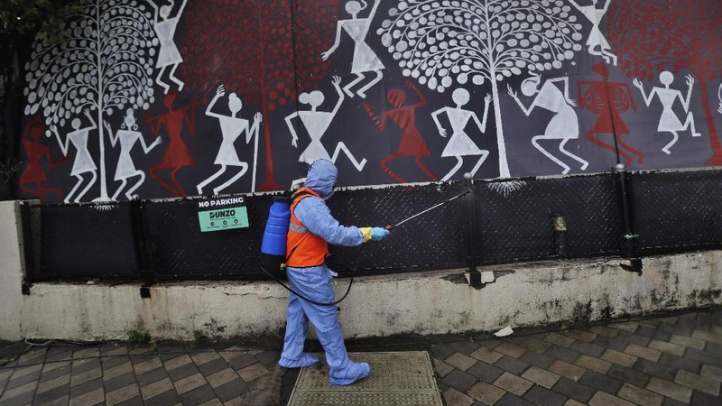 Civic workers sanitize the entrance of Bollywood superstar Amitabh Bachchan's residence after Bachchan and his son tested positive for the coronavirus and were hospitalized in Mumbai, India, Sunday, July 12, 2020. (AP Photo/Rafiq Maqbool)