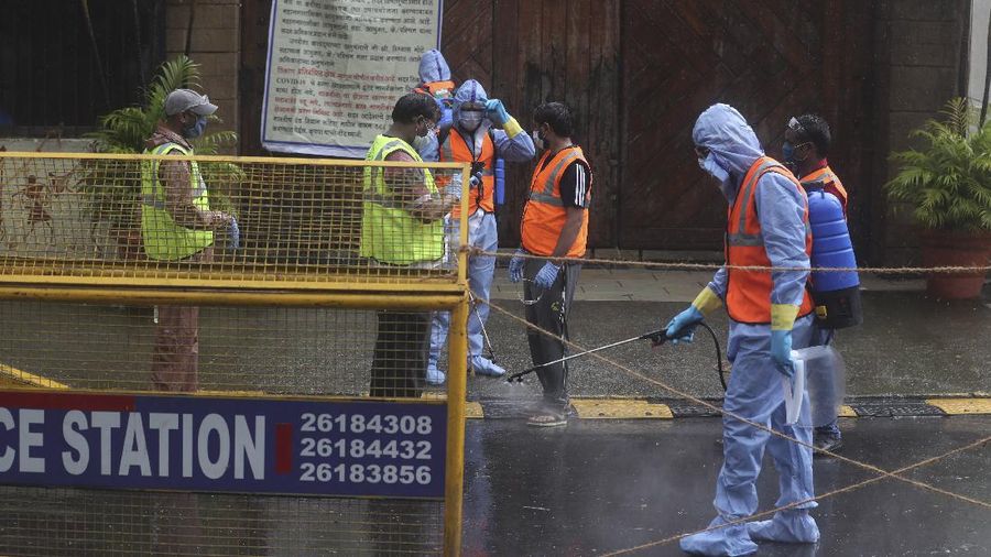 Civic workers sanitize the entrance of Bollywood superstar Amitabh Bachchan's residence after Bachchan and his son tested positive for the coronavirus and were hospitalized in Mumbai, India, Sunday, July 12, 2020. (AP Photo/Rafiq Maqbool)