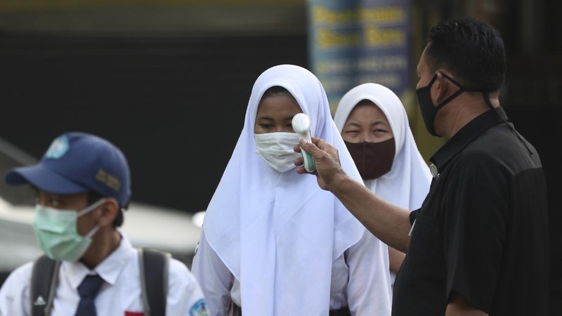 Siswa menggunakan masker dihari pertama masuk sekolah negeri di Bekasi. AP/Achmad Ibrahim