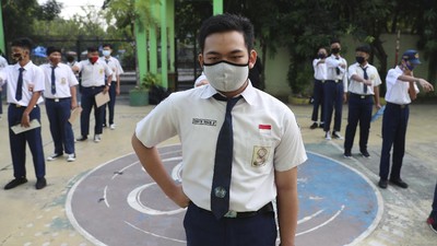 Siswa menggunakan masker dihari pertama masuk sekolah negeri di Bekasi. AP/Achmad Ibrahim