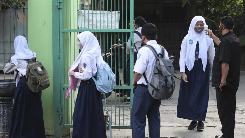 Siswa menggunakan masker dihari pertama masuk sekolah negeri di Bekasi. AP/Achmad Ibrahim