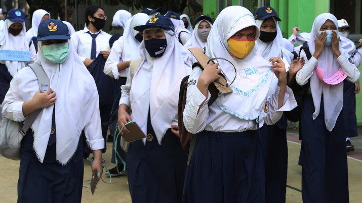 Siswa menggunakan masker dihari pertama masuk sekolah negeri di Bekasi. AP/Achmad Ibrahim Siswa menggunakan masker dihari pertama masuk sekolah negeri di Bekasi. AP/Achmad Ibrahim