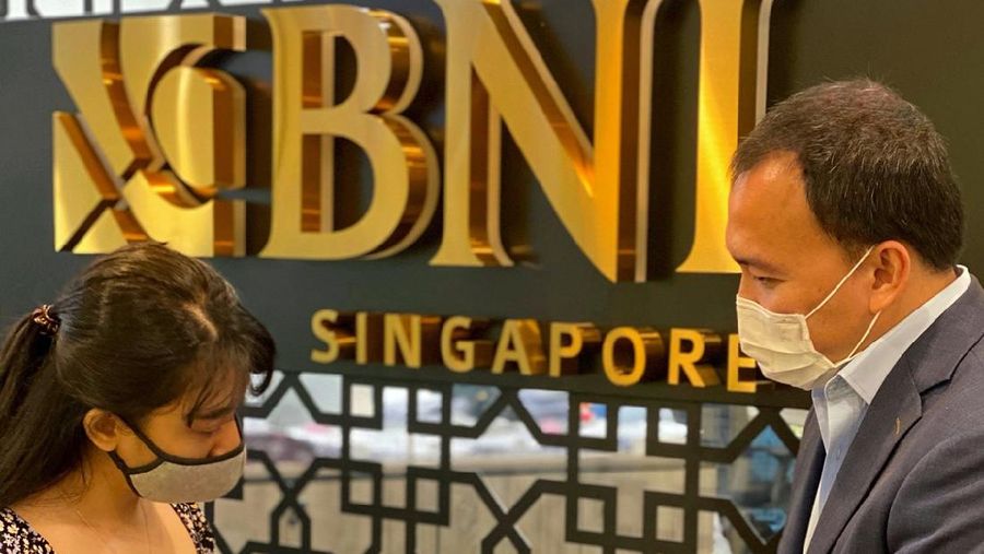Pegawai sedang membantu nasabah untuk melakukan aktivasi BNI MoRe di Kantor Cabang BNI Singapura.