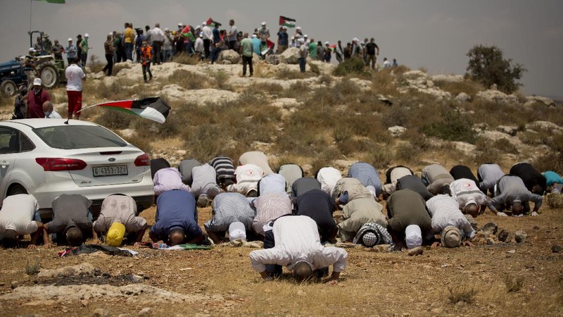 Muslim men keep social distancing to prevent the spread of coronavirus pandemic during Friday prayer, next to the Dome of the Rock Mosque in the Al Aqsa Mosque compound in Jerusalem's old city, Friday, July 10, 2020. (AP Photo/Mahmoud Illean)
