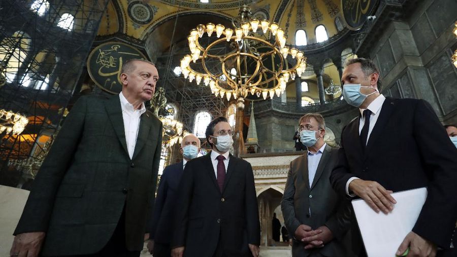 Turkey's President Recep Tayyip Erdogan, center, and other officials visit the Byzantine-era Hagia Sophia, one of Istanbul's main tourist attractions in the historic Sultanahmet district of Istanbul, Sunday, July 19, 2020, days after he formally reconverted Hagia Sophia into a mosque and declared it open for Muslim worship, after a high court annulled a 1934 decision that had made the religious landmark a museum.(Turkish Presidency via AP, Pool)