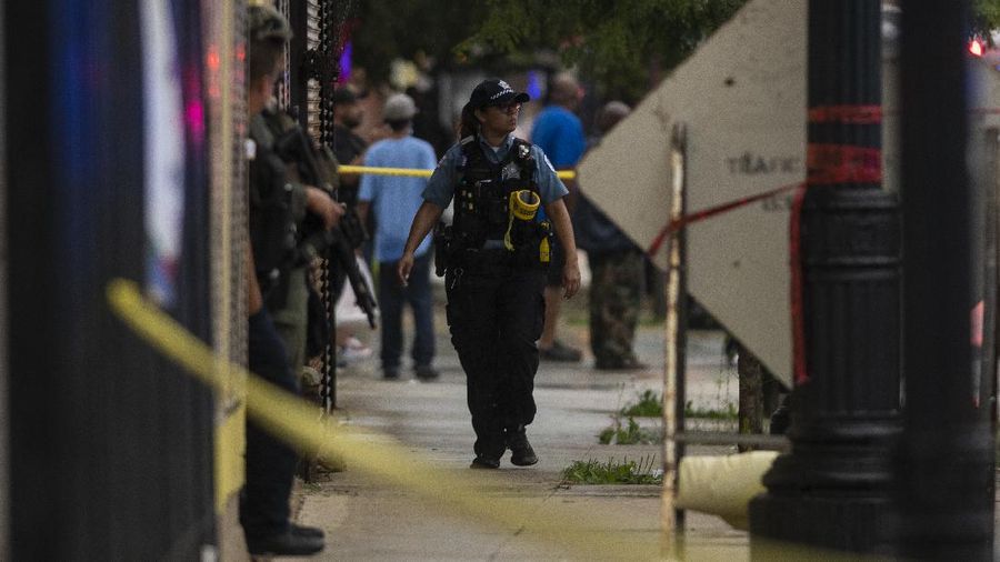 Chicago police investigate the scene of a mass shooting where more then a dozen people were shot in the Gresham neighborhood, of Chicago, Tuesday, July 21, 2020.  (Tyler LaRiviere/Chicago Sun-Times via AP)