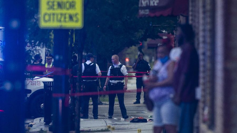 Chicago police investigate the scene of a mass shooting where more then a dozen people were shot in the Gresham neighborhood, of Chicago, Tuesday, July 21, 2020. (Tyler LaRiviere/Chicago Sun-Times via AP)