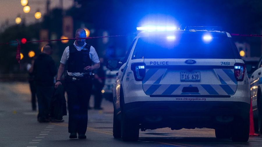 Chicago police investigate the scene of a mass shooting where more then a dozen people were shot in the Gresham neighborhood, of Chicago, Tuesday, July 21, 2020.  (Tyler LaRiviere/Chicago Sun-Times via AP)