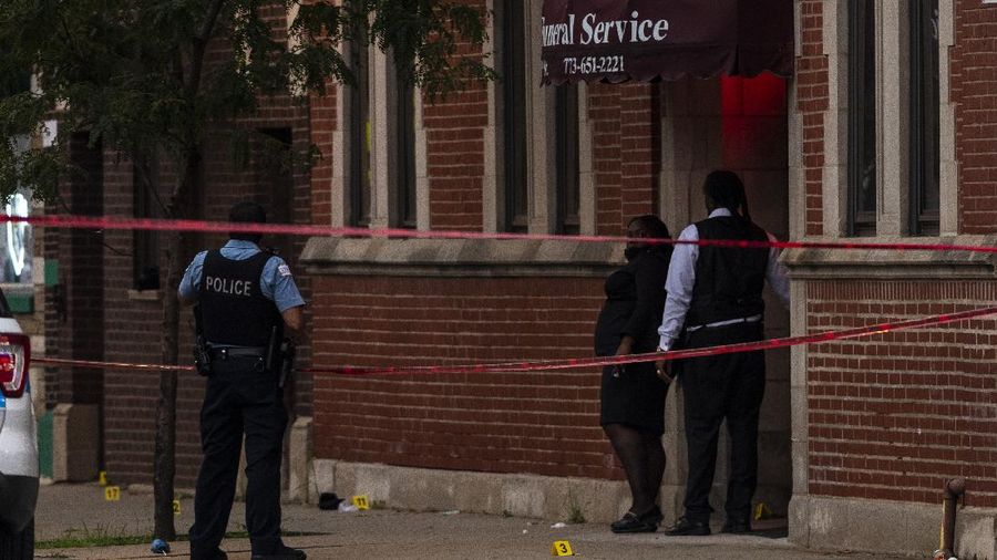 Chicago police investigate the scene of a mass shooting where more then a dozen people were shot in the Gresham neighborhood, of Chicago, Tuesday, July 21, 2020.  (Tyler LaRiviere/Chicago Sun-Times via AP)