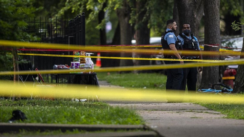 Chicago police investigate the scene of a mass shooting where more then a dozen people were shot in the Gresham neighborhood, of Chicago, Tuesday, July 21, 2020.  (Tyler LaRiviere/Chicago Sun-Times via AP)