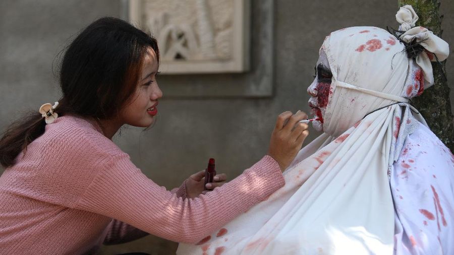 Seorang pemuda karang taruna mengenakan kostum pocong saat meminta sumbangan di kawasan Jombang, Tangerang Selatan, Rabu (22/7/2020). (CNBC Indonesia/ANdrean Kristianto)