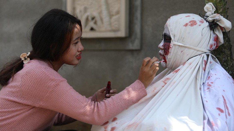 Seorang pemuda karang taruna mengenakan kostum pocong saat meminta sumbangan di kawasan Jombang, Tangerang Selatan, Rabu (22/7/2020). (CNBC Indonesia/ANdrean Kristianto)