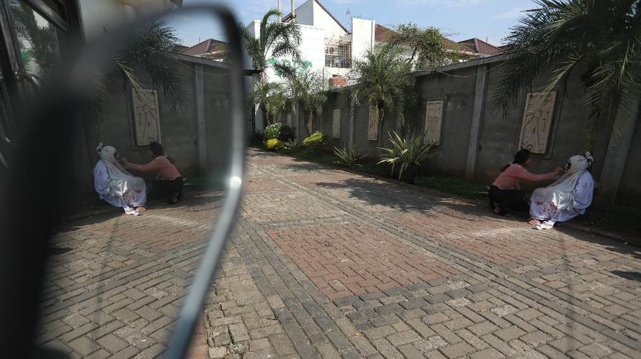 Seorang pemuda karang taruna mengenakan kostum pocong saat meminta sumbangan di kawasan Jombang, Tangerang Selatan, Rabu (22/7/2020). (CNBC Indonesia/ANdrean Kristianto)