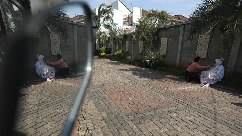 Seorang pemuda karang taruna mengenakan kostum pocong saat meminta sumbangan di kawasan Jombang, Tangerang Selatan, Rabu (22/7/2020). (CNBC Indonesia/ANdrean Kristianto)