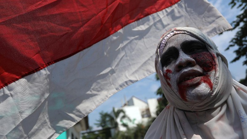 Seorang pemuda karang taruna mengenakan kostum pocong saat meminta sumbangan di kawasan Jombang, Tangerang Selatan, Rabu (22/7/2020). (CNBC Indonesia/ANdrean Kristianto)