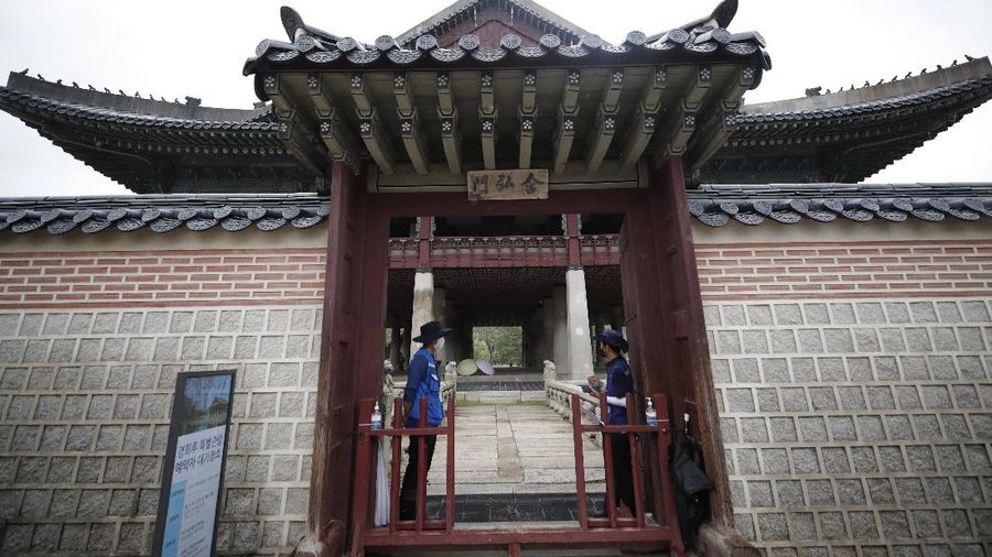 Workers wearing face masks to help protect against the spread of the new coronavirus stand to check visitors' temperature during a special tour of Gyeonghoeru pavilion at the Gyeongbok Palace, one of South Korea's well-known landmarks, in Seoul, South Korea, Wednesday, July 22, 2020. Just days after South Korean officials hopefully declared the country’s COVID-19 epidemic was coming under control, health authorities reported dozens of new cases following a dual rise in local transmissions and imported infections.(AP Photo/Lee Jin-man)