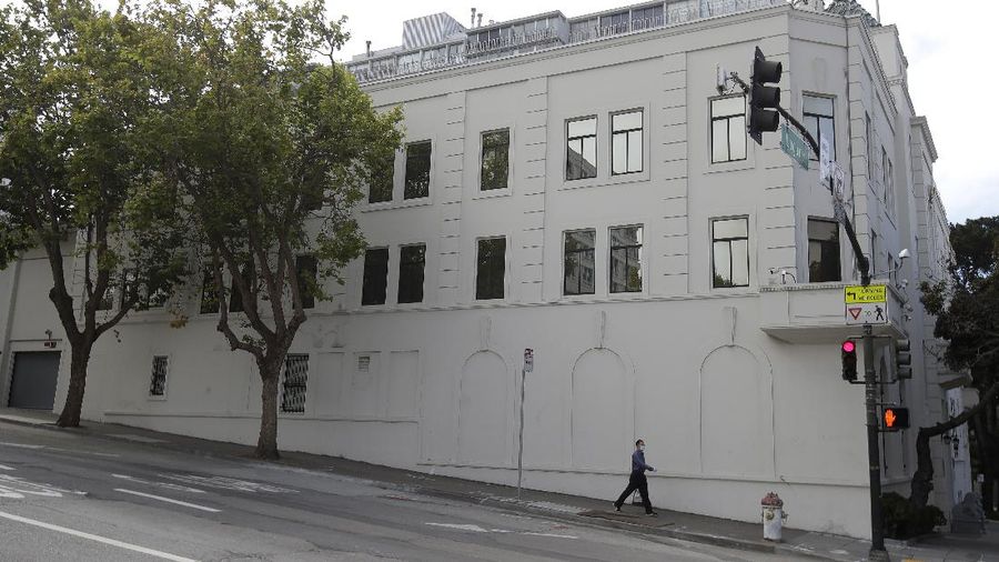 A pedestrian walks outside of the Chinese Consulate in San Francisco, Thursday, July 23, 2020. The Chinese consulate in San Francisco is harboring a Chinese researcher who the FBI says lied about her military background. (AP Photo/Jeff Chiu)