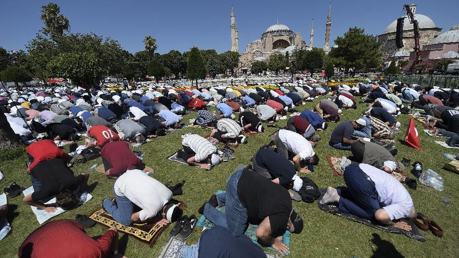 Muslims pray during Friday prayers at the historic Sultanahmet district of Istanbul, near the Byzantine-era Hagia Sophia, background, Friday, July 24, 2020. Thousands of Muslim faithful surrounded Istanbul's landmark monument Friday to take part in the first prayers in 86 years at the structure that was once Christendom's most significant cathedral and the