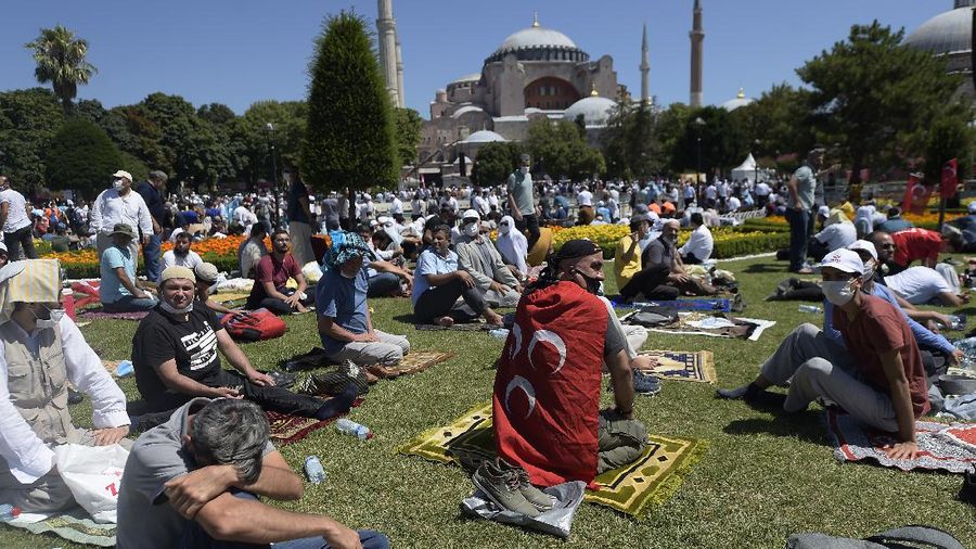 A man waves a Turkish flag outside the Byzantine-era Hagia Sophia, in the historic Sultanahmet district of Istanbul, Friday, July 24, 2020. Hundreds of Muslim faithful were making their way to Istanbul's landmark monument Friday to take part in the first prayers in 86 years at the structure that was once Christendom's most significant cathedral and the 
