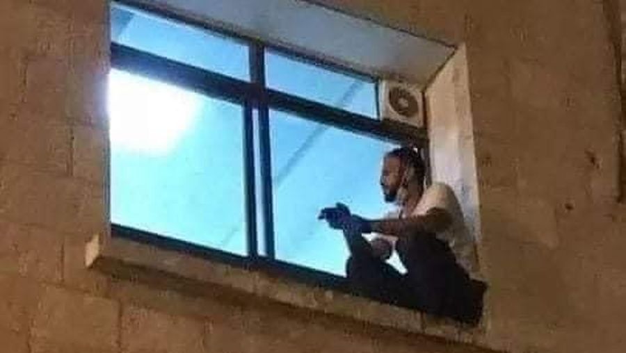 Seorang pria naik ke jendela rumah sakit saat ibunya dirawat akibat Covid-19. (Tangkapan Layar Twitter @mhdksafa)