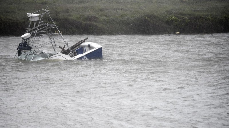 A boat sinks in the Packery Channel during Hurricane Hanna, Saturday, July 25, 2020, in North Padre Island, Texas. The Category 1 storm continued to strengthen before reaching Padre Island at 5 p.m. Saturday. (Annie Rice/Corpus Christi Caller-Times via AP)