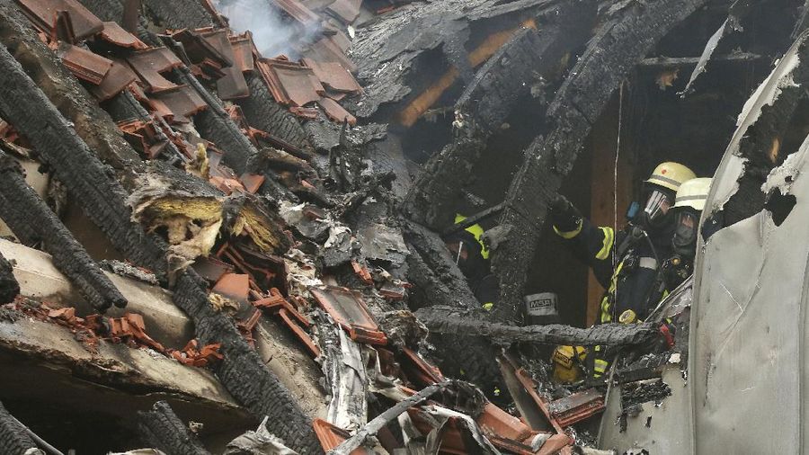 Emergency services attend the scene after a light plane crashed into an apartment building in Wesel, Germany, Saturday July 25, 2020. Three people died on Saturday after an ultra-light aircraft crashed into the apartment building and caught fire.(David Young/dpa via AP)