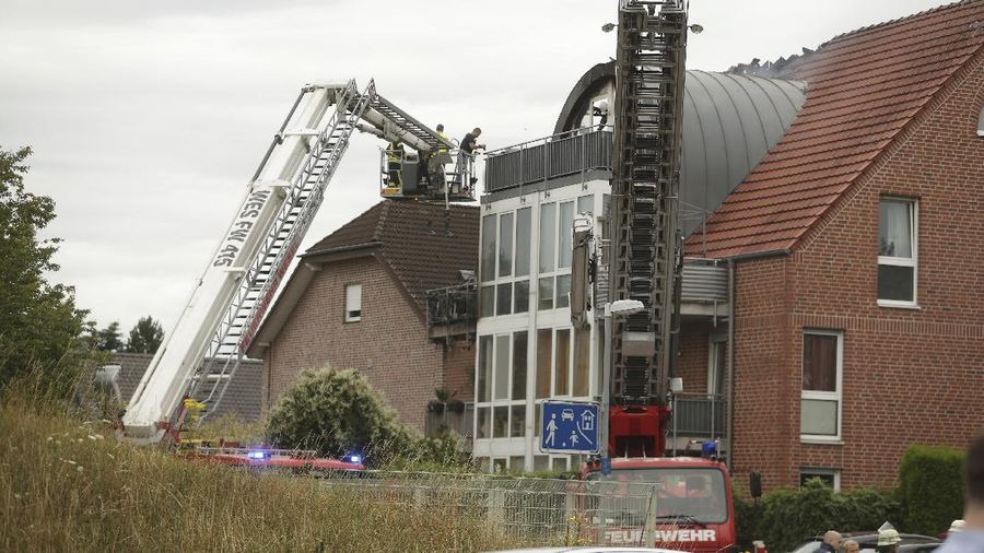 Emergency services attend the scene after a light plane crashed into an apartment building in Wesel, Germany, Saturday July 25, 2020. Three people died on Saturday after an ultra-light aircraft crashed into the apartment building and caught fire.(David Young/dpa via AP)