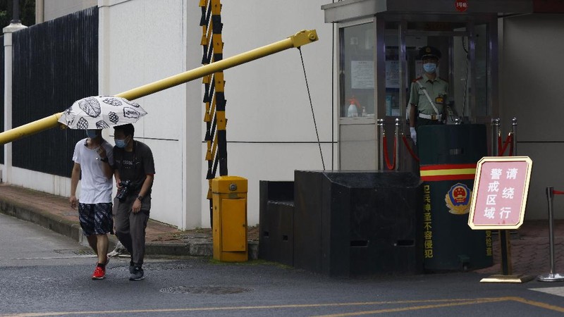 Workers prepare to cover up the areas where the signage used to show the location as United States Consulate in Chengdu in southwest China's Sichuan province on Monday, July 27, 2020. Chinese authorities took control of the former U.S. consulate in the southwestern Chinese city of Chengdu on Monday after it was ordered closed in retaliation for a U.S. order to vacate the Chinese Consulate in Houston. (AP Photo/Ng Han Guan)